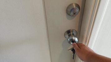 Man hand use a key for lock or unlock wooden door