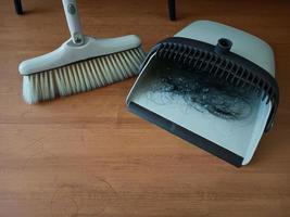 barrer el polvo con una escoba en un recogedor, concepto de limpieza.