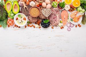 concepto de dieta cetogénica baja en carbohidratos. ingredientes para la selección de alimentos saludables sobre fondo blanco de madera. foto