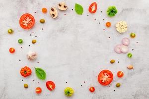 The ingredients for homemade pizza set up on white concrete background. photo