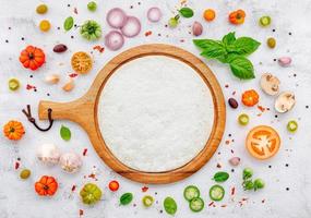 The ingredients for homemade pizza set up on white concrete background. photo