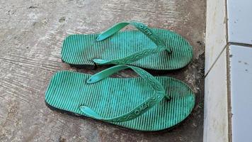Cianjur Regency, West Java, Indonesia on March 16, 2022 Two pairs of flip-flops in the yard.  Photos to complement the article.