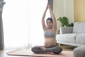 joven embarazada haciendo yoga en casa, atención médica y concepto de atención del embarazo