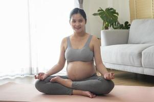 Young pregnant woman doing yoga at home, healthcare and pregnancy care concept photo