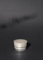 moisturizing cream bottle over black background studio, packing and skincare beauty concept