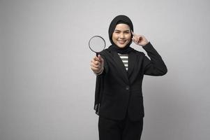 Muslim business woman holding Magnifier isolated on white background photo