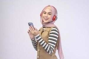 Young beautifu musliml woman wearing headset on white background photo