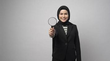 Muslim business woman holding Magnifier isolated on white background photo