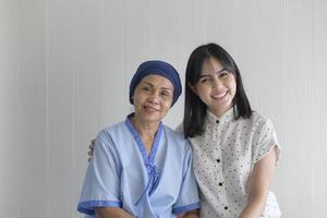 Cancer patient woman wearing head scarf and her supportive daughter in hospital, health and insurance concept. photo