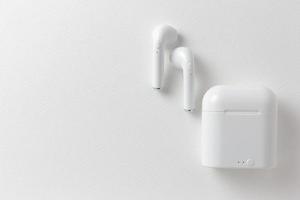 Modern wireless earphones and charging case on white background, flat lay.jpg photo