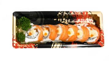 Salmon sushi roll with spicy sauce on white background. photo