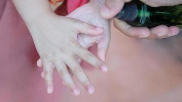 Child's hand was drenched with an alcohol spray, sprayed by her father. photo