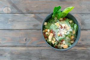 Caesar salad with cos romaine lettuce, crispy bacon, croutons and parmesan cheese. photo