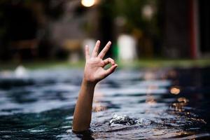 Hand and water love hand that comes out of the water that is also shown ok. photo