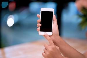 las manos y los teléfonos con pantalla están vacíos. conceptos de comunicación telefónica blanca por teléfono y para hacer negocios en línea. foto