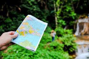 un turista y su mapa en un viaje al bosque en tailandia. rico en pastos y arroyos. foto