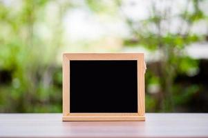 The empty chalk on the wooden floor above has the sun and green background blurred. The bokeh background template is for the montage of your product and has a copy space. photo