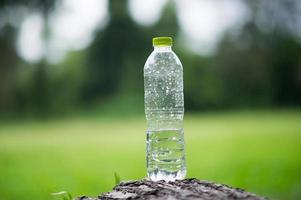 A bottle of water is left on the plate, not half the bottle. And a light green background. Health care concept And drinking water. photo