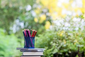 lápices y libros se colocan sobre suelos de madera. foto