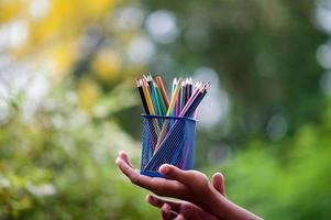 Hands and pencils in many colors photo