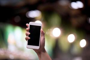 las manos y los teléfonos con pantalla están vacíos. conceptos de comunicación telefónica blanca por teléfono y para hacer negocios en línea. foto