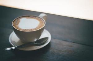 A cup of coffee and coffee beans on the table of coffee lovers coffee. photo