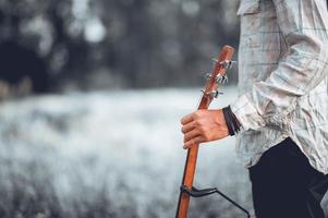 The man's hand plays the acoustic guitar, plays the guitar in the garden alone, happily and loves the music. photo