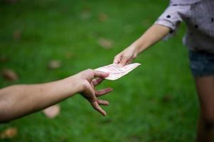 mano y dinero para pagarse unos a otros es algo bueno y debe compartir la felicidad entre ellos. dando dinero foto