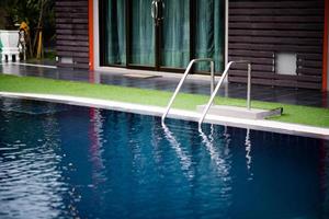 piscina con agua azul clara hay un reflejo en el agua, un concepto de piscina saludable. foto