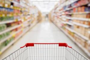Shopping cart view in Supermarket aisle with product shelves abstract blur defocused background photo