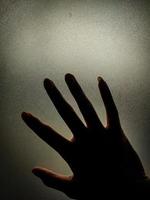 Right hand silhouette on frosted glass photo