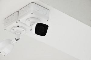 mini cámara ip cctv instalada en un poste de metal fuera de la casa, fondo azul, concepto para usar tecnología para salvar vidas, seguridad y propiedad. enfoque suave y selectivo. foto