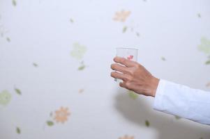 Hand and glass of water for drinking. photo