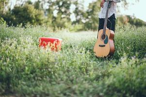 The man's hand plays the acoustic guitar, plays the guitar in the garden alone, happily and loves the music. photo