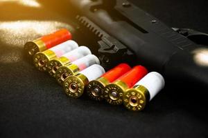 Shotgun, shotgun cartridges on a black leather background, soft and selective focus photo