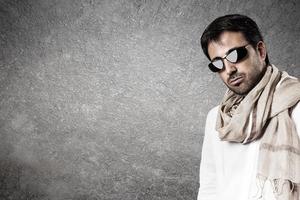 hombre seductor con gafas de sol y bufanda. imagen vertical foto