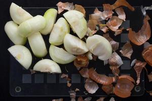 Cut in half peeled onion and peels photo