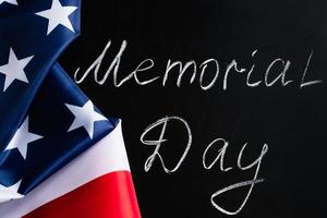 Memorial day concept. Handwritten lettering on black chalkboard and American flag. photo