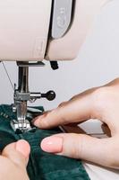 mujer sastre trabaja en máquina de coser. día mundial de los sastres.