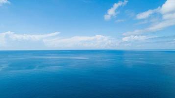 Aerial view of a blue sea surface water texture background and sun reflections Aerial flying drone view Waves water surface texture on sunny tropical ocean in Phuket island Thailand photo