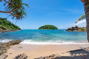 Leaves frame with Summer sea beach Amazing sea clear blue sky and clouds Wave crashing on seashore tree leaves beautiful leafs frame over sea Copy space photo