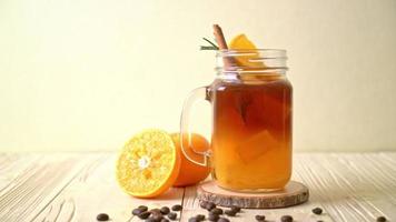 un verre de café noir americano glacé et une couche de jus d'orange et de citron décoré de romarin et de cannelle video