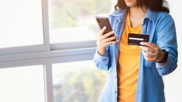 Asian woman using smartphone paying and shopping with smartphone application, online payment, banking and online shopping at the office, Digital money transfer, banking and e commerce concept. photo