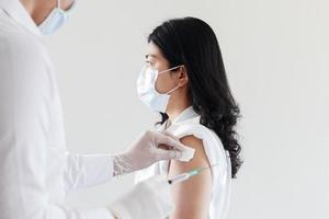 doctor dando vacuna covid a mujeres asiáticas