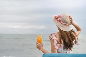 Relax woman drinking refresh orange cocktail on the beach photo