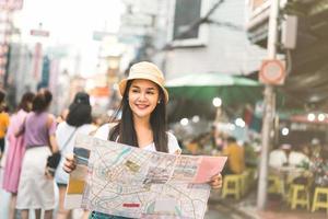 mujer asiática buscando con un mapa en el barrio chino foto