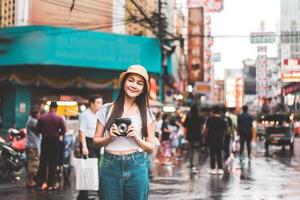 Solo traveller woman with instant camera in bangkok thailand. photo