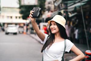 foto selfie de mujer viajera con cámara instantánea.