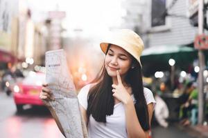 Young adult asian woman solo travel using map outdoor on day photo