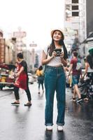 Young asian traveller woman with instant camera in Bangkok, Thailand photo